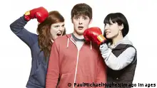 Teenage siblings fighting with boxing gloves on white background