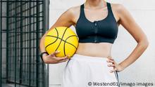 Basketball player with sports ball and hand on hip model released Symbolfoto EGHF00173 