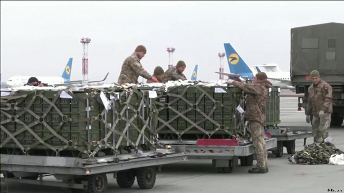 Militares descarregam caixas no aeroporto. 