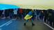 A child wearing a Ukrainian flag walks underneath a larger Ukrainian flag in Kyiv A child wearing a Ukrainian flag walks underneath a larger Ukrainian flag in Kyiv