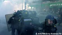 French police use teargas while facing demonstrators in this screen grab taken from a video during a Convoi de la liberte (The Freedom Convoy), a vehicular convoy to protest coronavirus disease (COVID-19) vaccine and restrictions in Paris, France, February 12, 2022. REUTERS via Reuters TV