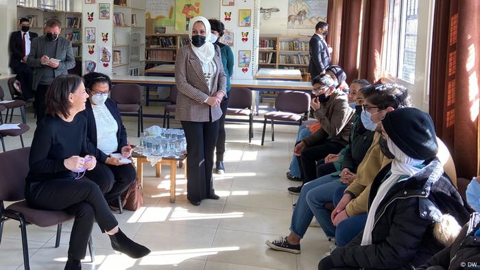 Annalena Baerbock sits in a room with refugees in Jordan. 