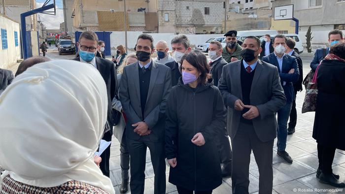 Annalena Baerbock surrounded by delegates on a visit to a refugee camp in Jordan 