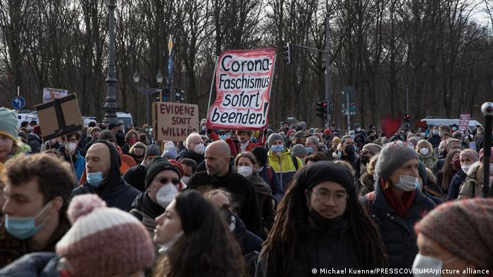 A person carries a sign reading 'Stop Corona fascism now' during a protest against COVID curbs in Berlin, Germany