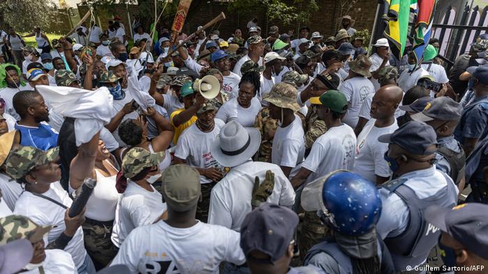 Demonstrators gather in front of police in Johannesburg