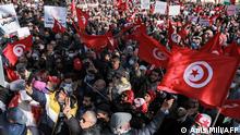 Protesters wave Tunisian national flags during a demonstration called for by Tunisia's Islamist-inspired Ennahdha party against President Kais Saied's recent decrees, outside the Tunis Opera House in the centre of the capital Tunis on February 13, 2022. - Over a thousand demonstrators gathered in the centre of Tunis on February 13 a few hours after Saied replaced the Supreme Judicial Council (CSM), which he had dissolved a week prior, with another temporary body and gave himself the power to sack judges and prohibit their strikes. (Photo by ANIS MILI / AFP)