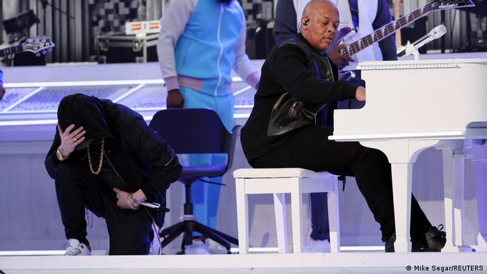 Rapper Eminem took a knee during the Super Bowl halftime show while Dr. Dre plays the piano 