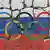 Олимпийские кольца на фоне потрескавшейся стены в цветах флага РФ