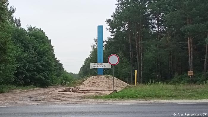 Signpost indicating the edge of the Brestskiy training ground, next to a forest