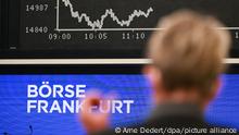 Eine Frau steht auf dem Parkett der Frankfurter Wertpapierbörse vor der Dax-Kurve, die fallende Kurse darstellt. Der Ukraine-Konflikt wird zu Beginn der Handelswoche am Aktienmarkt zu einer großen Belastung. Ein befürchteter Einmarsch Russlands in das Nachbarland hatte schon die Kurse an den US-Börsen auf Talfahrt geschickt. Der Deutsche Aktienindex (Dax) fiel zum Handelsstart unter die Marke von 15 000 Punkten. +++ dpa-Bildfunk +++