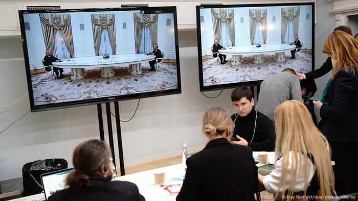 Journalisten verfolgen per TV-Monitoren die ersten Minuten des Tischgesprächs von Putin und Scholz im Kreml Journalisten verfolgen per TV-Monitoren die ersten Minuten des Tischgesprächs von Putin und Scholz im Kreml