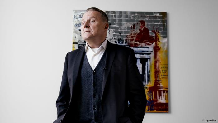 Der AfD-Politiker Georg Pazderski steht im Anzug vor einem großen Gemälde. Szene aus dem Dokumentarfilm Eine deutsche Partei.