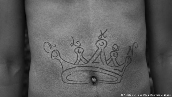 Corona tatuada sobre una panza. 