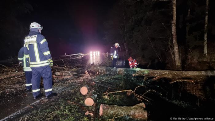 Firefighters work to clear a tree from a road in Germany's Sauerland region