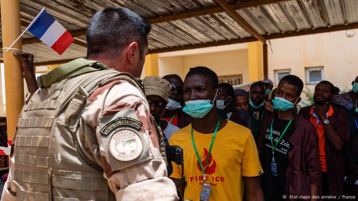 A member of France's Operation Barkhane speaks with locals in Mali