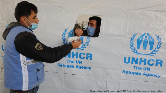 Palestinian employees at the United Nations Relief and Works Agency for Palestinian Refugees (UNRWA) prepare food aid rations for refugees. 