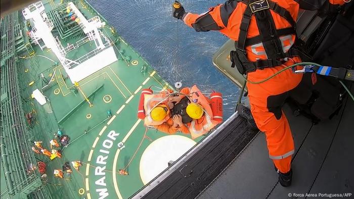 Two men hang from from a wire above a deck of Felicity Ace