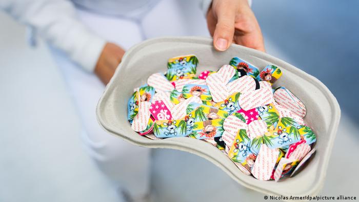 Hand holds tray with colorful bandaids for kids