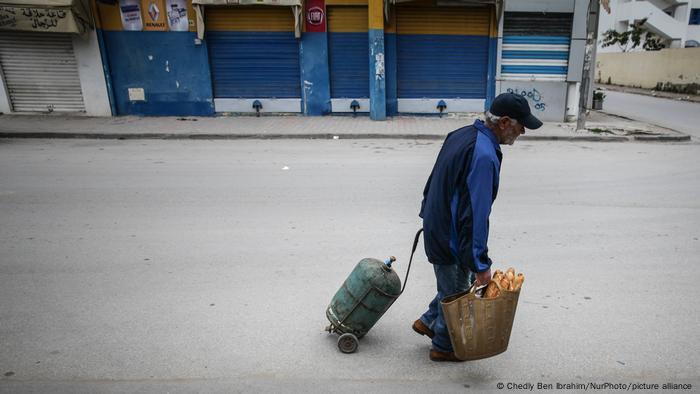 رجل يجر اسطوانة غاز في مدينة أريانا التونسية