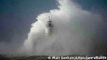 Waves crash over the Newhaven harbour breakwater and lighthouse, as Storm Eunice hits Newhaven, on the south coast of England, Friday, Feb. 18, 2022. Millions of Britons are being urged to cancel travel plans and stay indoors Friday amid fears of high winds and flying debris as the second major storm this week prompted a rare red weather warning, meaning there is a danger to life, across southern England. (AP Photo/Matt Dunham)