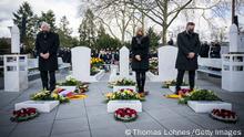 HANAU, GERMANY - FEBRUARY 19: Nancy Faeser (C), German Minister for Interior and Community, Hessian State Premier Volker Bouffier (L) and Hanau's Lord Mayor Claus Kaminsky (R) commemorate the victims of the 2020 mass shooting at the main cemetery on February 19, 2022 in Hanau, Germany. On February 19, 2020 Tobias Rathjen shot dead nine people with immigrant backgrounds in a shooting spree in the city center before killing himself and his mother. In days before the shootings he had posted an online manifesto laden with xenophobia and conspiracy claims. (Photo by Thomas Lohnes/Getty Images)