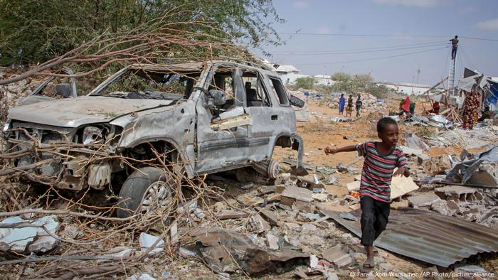A young boy runs past the wreckage of a vehicle destroyed in an attack on police and checkpoints on the outskirts of the capital Mogadishu.