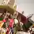 Des manifestants célébrant avec des trompettes et des drapeaux aux couleurs du Mali