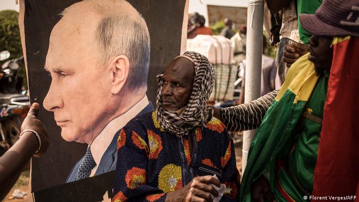 Afrikaner halten ein großes Porträt von Wladimir Putin hoch