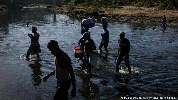 People cross the Massacre River into the Dominican Republic at the Dajabon border crossing