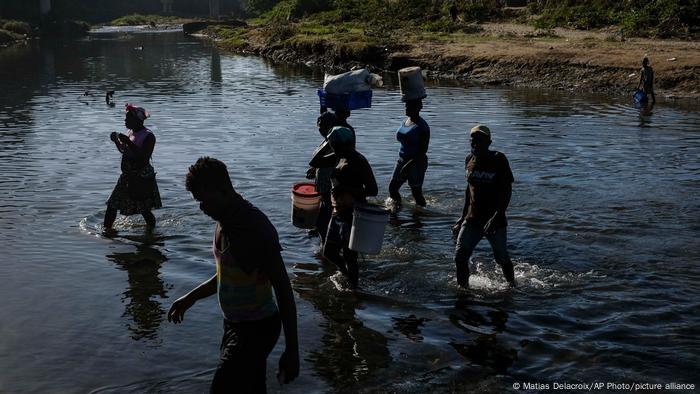 People cross the Massacre River into the Dominican Republic at the Dajabon border crossing