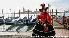 A masked reveller wearing a traditional carnival costume poses on St Mark Square, Venice on February 20, 2022, during the annual carnival. (Photo by ANDREA PATTARO / AFP) (Photo by ANDREA PATTARO/AFP via Getty Images)