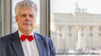 Christian Höppner in a blue suit with a red bow tie and glasses.
