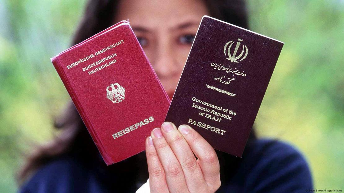 Një grua tregon pasaportën gjermane dhe atë iraniane
