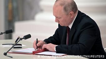 Президент РФ Владимир Путин подписывает документ