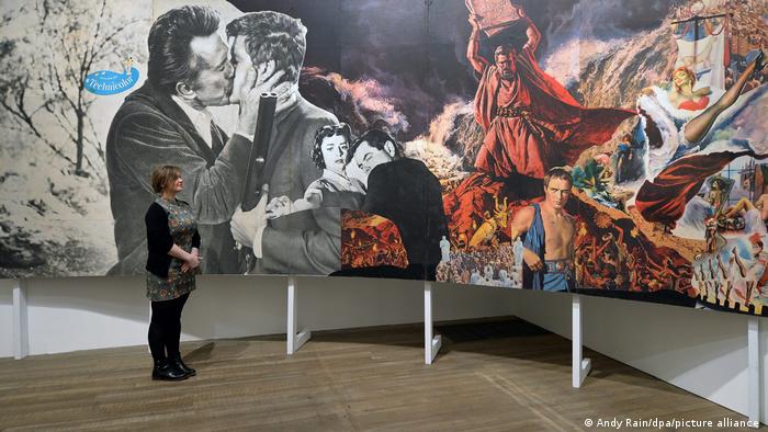 A woman stands in front of a collage of images that appear to be taken from books and film.