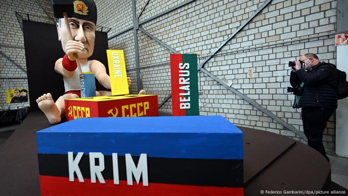 Float that shows Putin figure witjh hat and building blocs 