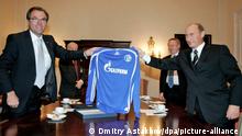 Der russische Präsident Wladimir Putin (r) und Clemens Tönnies, Aussichtsratsvorsitzender des Bundesligavereins Schalke 04, halten ein Schalke-Trikot mit der Aufschrift des neuen Sponsors Gazprom am Dienstag (11.10.2006) in Dresden. Das russsiche Erdgasunternehmen Gazprom wird neuer Sponsor von Schalke 04. Foto:Dmitry Astakhov/Pool) +++(c) dpa - Report+++