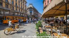 View of restaurant, tram and pedestrians on Via Dante, Milan, Lombardy, Italy, Europe