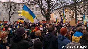 Демонстранты держат украинские флаги на акции солидарности с Украиной в Берлине
