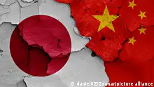 flags of Japan and China painted on cracked wall