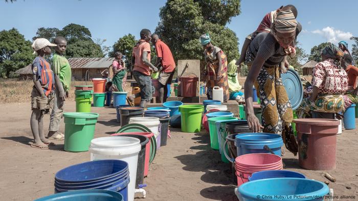 Women and children fetch water at a borehole.