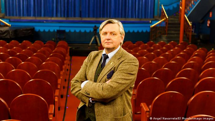 Filmmaker Sergeij Loznitsa stands in a cinema hall with his arms folded.