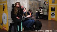 Girls hold their mobile phone as they take refuge in a metro station in Kyiv in the morning of February 24, 2022. Air raid sirens rang out in downtown Kyiv today as cities across Ukraine were hit with what Ukrainian officials said were Russian missile strikes and artillery. - Russian President Vladimir Putin announced a military operation in Ukraine on Thursday with explosions heard soon after across the country and its foreign minister warning a full-scale invasion was underway. (Photo by Daniel LEAL / AFP) (Photo by DANIEL LEAL/AFP via Getty Images)