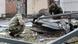 Soldados examinam os restos de um foguete em uma praça na capital ucraniana