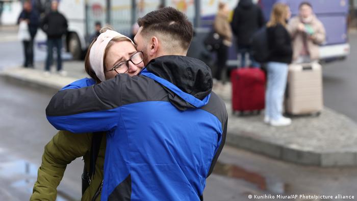 A Ukrainian couple hug at a street after deciding to leave Lviv in western Ukraine for Poland, a neighboring country to evacuate on Feb. 24, 2022