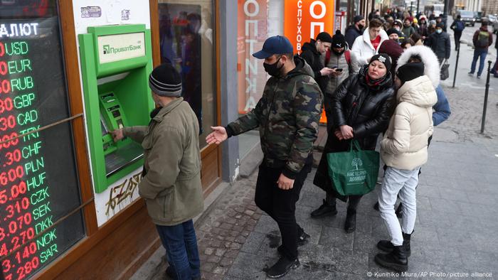 Locals form a long line to withdraw a cash from an ATM in Lviv, in western Ukraine, on February 24, 2022