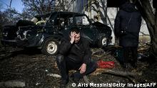 TOPSHOT - A man sits outside his destroyed building after bombings on the eastern Ukraine town of Chuguiv on February 24, 2022, as Russian armed forces are trying to invade Ukraine from several directions, using rocket systems and helicopters to attack Ukrainian position in the south, the border guard service said. - Russia's ground forces on Thursday crossed into Ukraine from several directions, Ukraine's border guard service said, hours after President Vladimir Putin announced the launch of a major offensive. Russian tanks and other heavy equipment crossed the frontier in several northern regions, as well as from the Kremlin-annexed peninsula of Crimea in the south, the agency said. (Photo by Aris Messinis / AFP) (Photo by ARIS MESSINIS/AFP via Getty Images)
