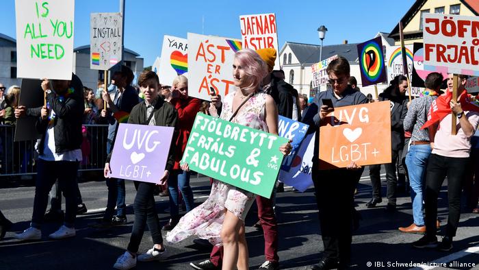 Scores of people holding LGBTQ+ placards in the streets of Reykjavik
