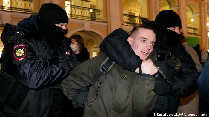 Police officer detain an anti-war demonstrator in St. Petersburg, Russia