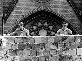 Zwei ostdeutsche Arbeiter errichten in der Bernauer Straße ein Stück der Mauer , Quelle: AP